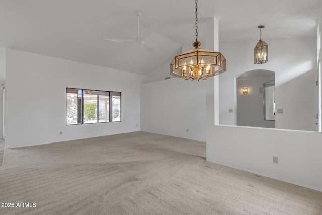 unfurnished room featuring arched walkways, ceiling fan with notable chandelier, high vaulted ceiling, and carpet floors