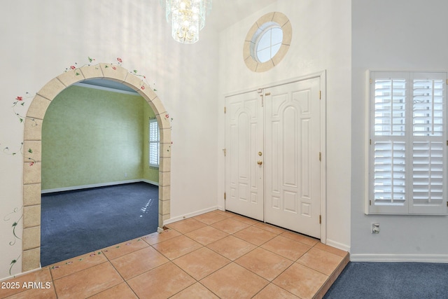 tiled foyer with a wealth of natural light and an inviting chandelier