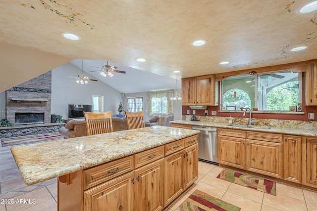 kitchen with a large fireplace, vaulted ceiling, sink, dishwasher, and a kitchen island