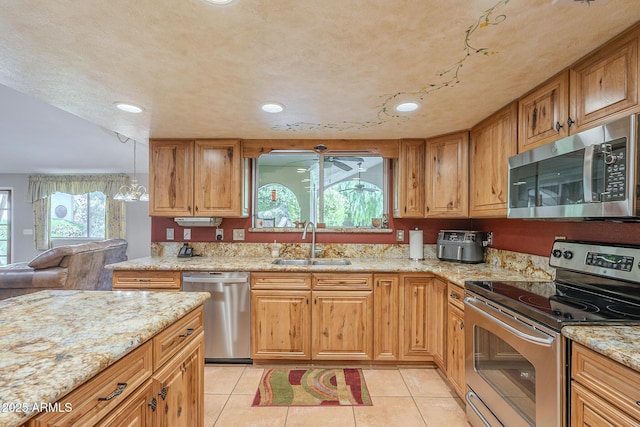 kitchen with sink, light tile patterned floors, stainless steel appliances, and a chandelier