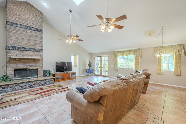 living room featuring a stone fireplace, ceiling fan, light tile patterned flooring, and high vaulted ceiling