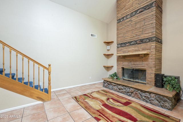 tiled living room with a fireplace and high vaulted ceiling