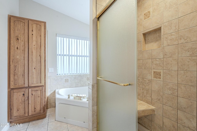 bathroom with tile patterned flooring, shower with separate bathtub, lofted ceiling, and tile walls