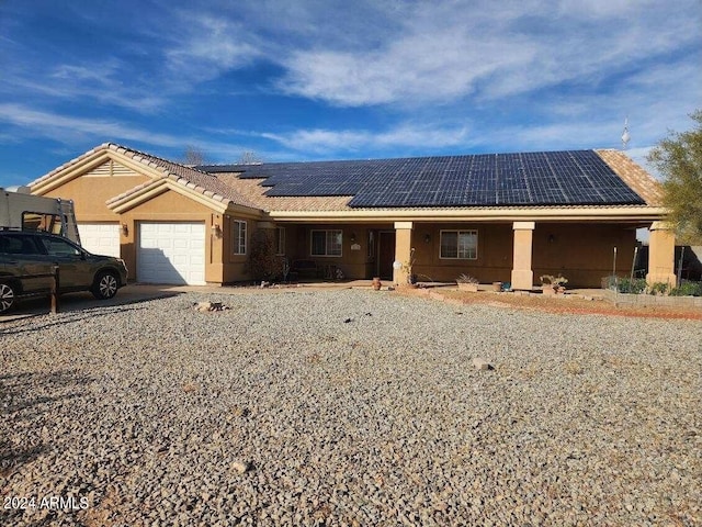 ranch-style home with solar panels and a garage