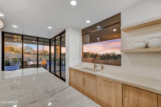 bathroom featuring a healthy amount of sunlight, sink, and a wall of windows