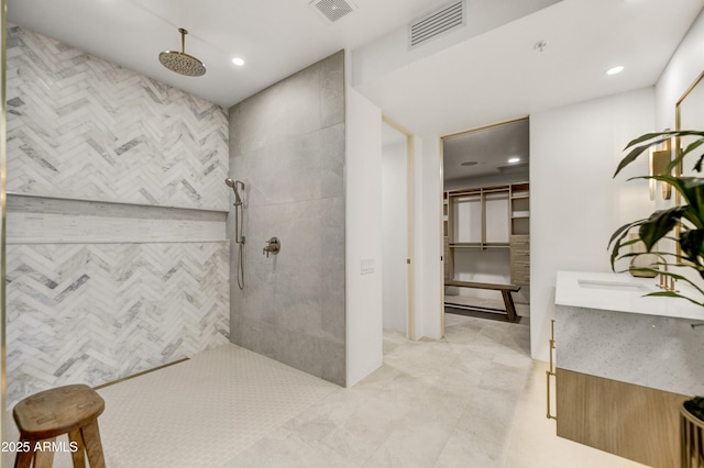 bathroom featuring a tile shower and vanity