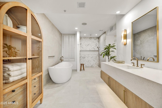 bathroom featuring vanity, a bathing tub, and tile walls