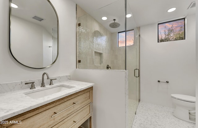 bathroom featuring tile patterned flooring, vanity, toilet, and walk in shower