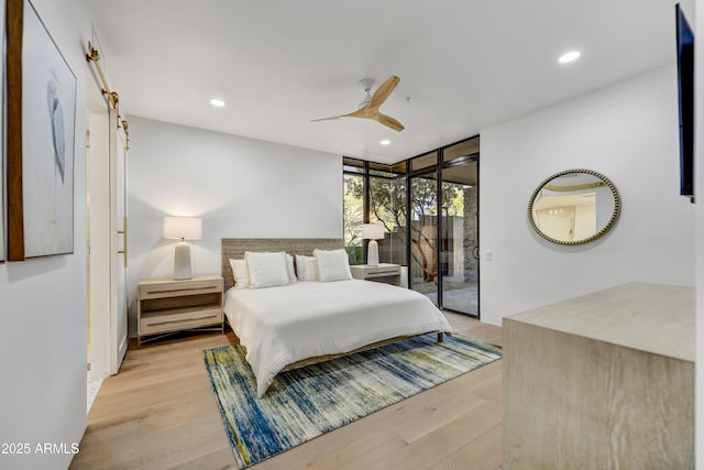 bedroom featuring access to exterior, light hardwood / wood-style floors, floor to ceiling windows, and ceiling fan