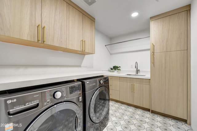 laundry area featuring cabinets, washing machine and clothes dryer, and sink