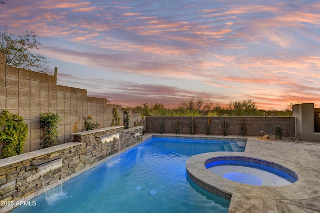 pool at dusk with pool water feature and an in ground hot tub