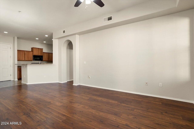 unfurnished living room with ceiling fan and dark hardwood / wood-style floors