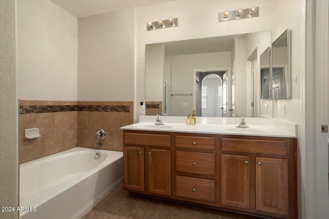 bathroom with a bathing tub, vanity, and tile patterned floors