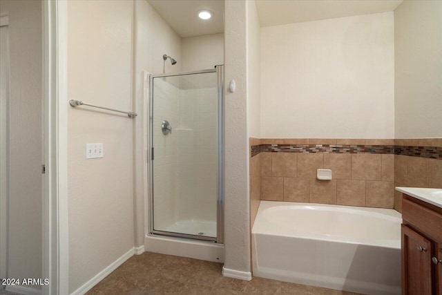 bathroom featuring tile patterned flooring, vanity, and shower with separate bathtub