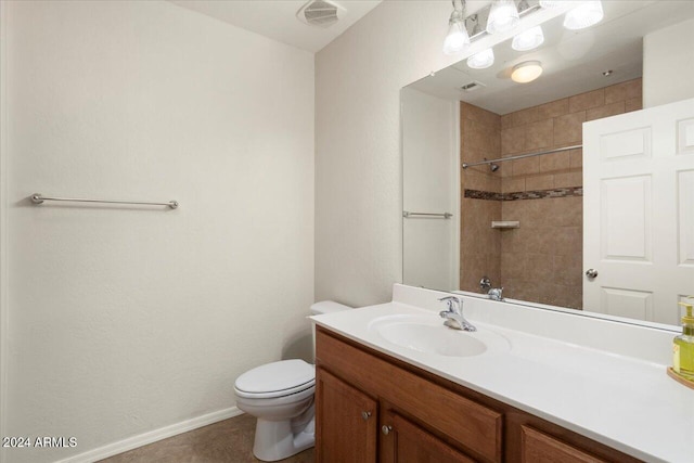 bathroom featuring toilet, vanity, tile patterned floors, and tiled shower