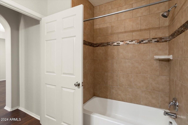 bathroom featuring tiled shower / bath combo and hardwood / wood-style flooring