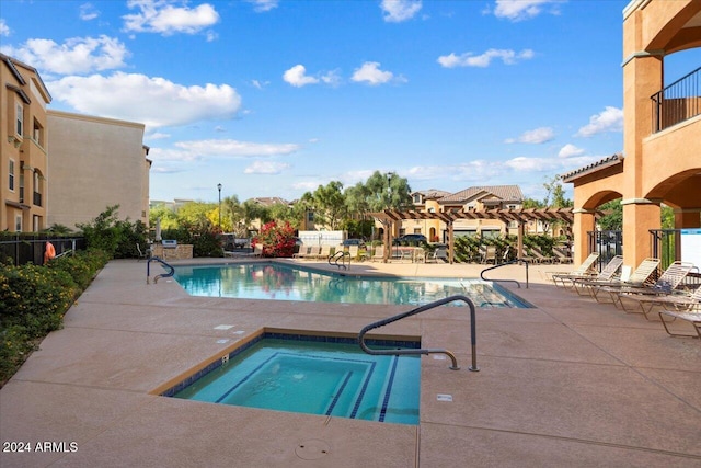 view of pool with a community hot tub, a pergola, and a patio