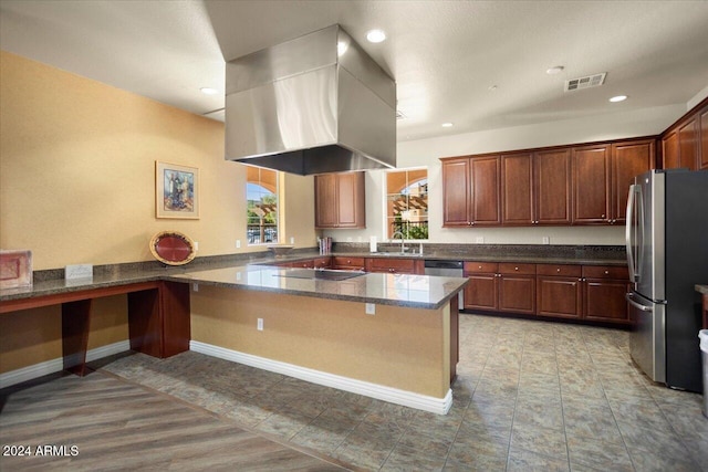 kitchen featuring range hood, kitchen peninsula, sink, and stainless steel appliances