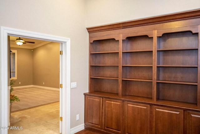 interior details with carpet floors, ornamental molding, baseboards, and ceiling fan