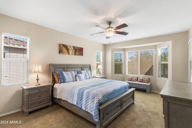 carpeted bedroom with multiple windows and ceiling fan