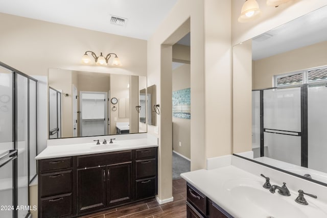 bathroom featuring wood-type flooring, vanity, and a shower with shower door