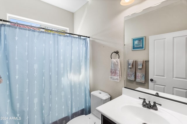 bathroom featuring curtained shower, vanity, and toilet