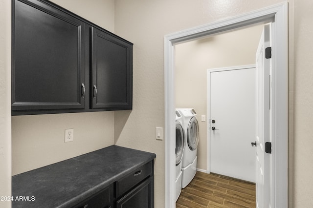 laundry room featuring cabinets, washer and dryer, and dark wood-type flooring