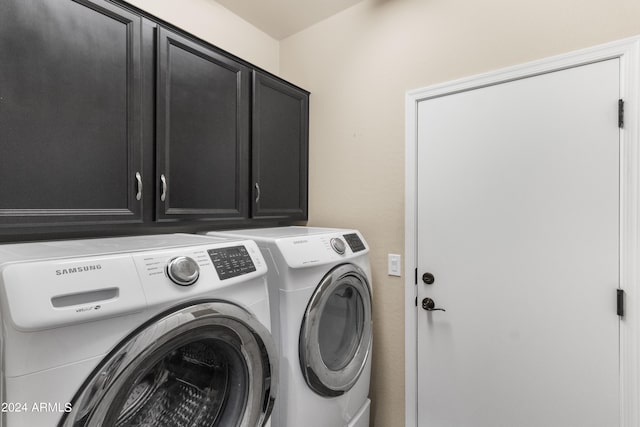 washroom featuring washing machine and dryer and cabinets