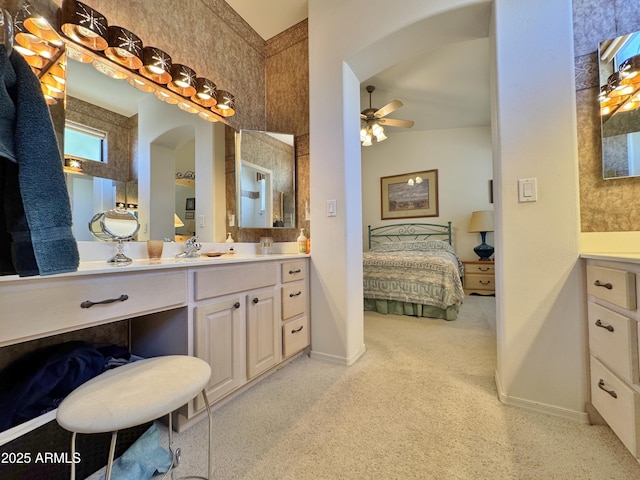 ensuite bathroom with ceiling fan, baseboards, connected bathroom, and vanity