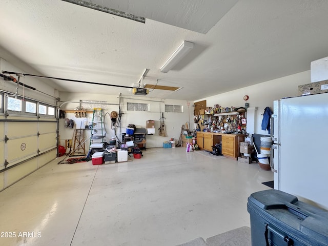 garage with a garage door opener and freestanding refrigerator