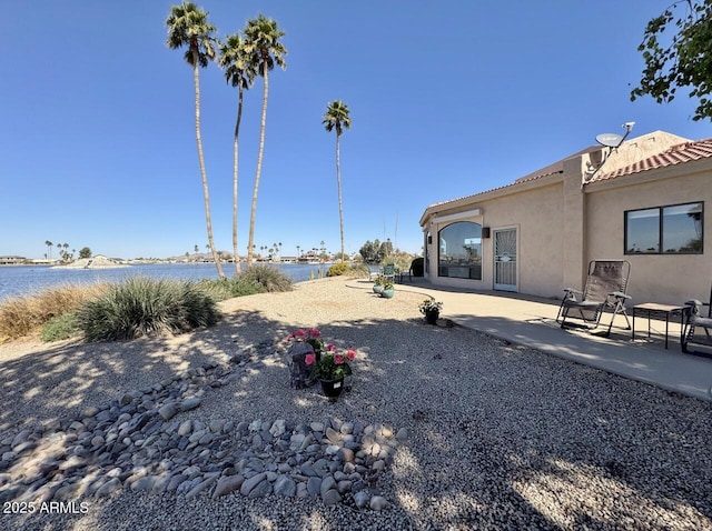 view of yard with a water view and a patio area