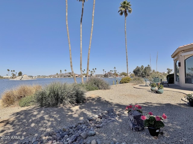 view of yard with a water view and a patio