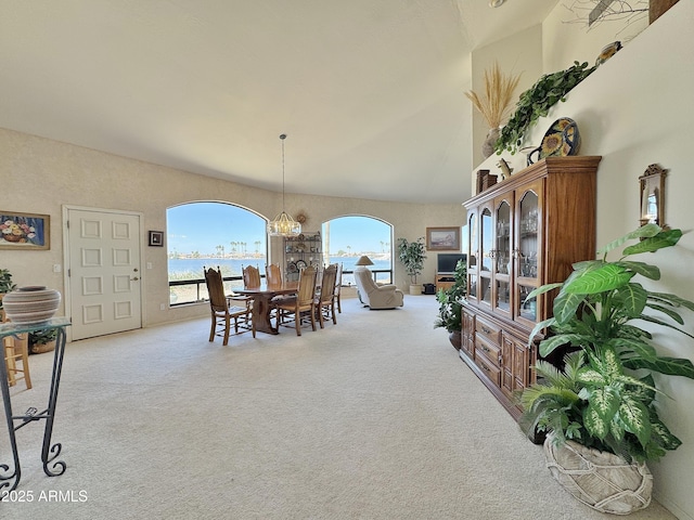 dining room with carpet flooring, a towering ceiling, and an inviting chandelier