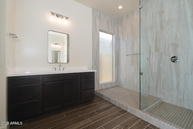 bathroom with vanity and a tile shower