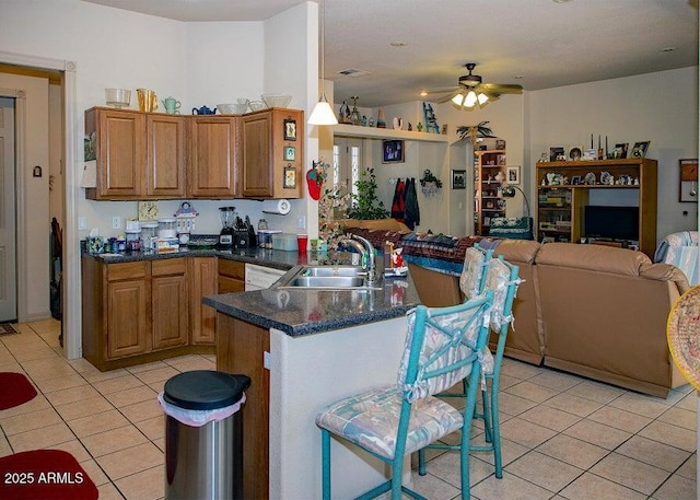 kitchen featuring pendant lighting, sink, ceiling fan, light tile patterned flooring, and kitchen peninsula