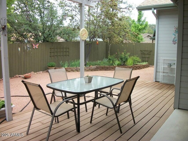 wooden deck with outdoor dining area and a fenced backyard