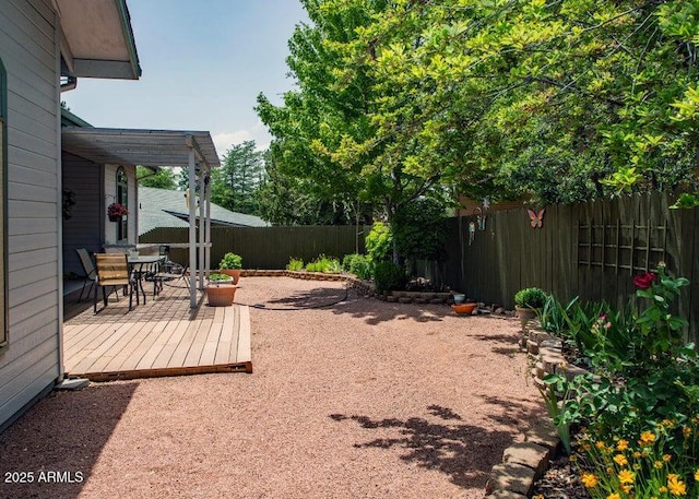 fenced backyard featuring outdoor dining space and a deck