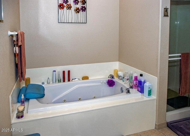 bathroom with a tub to relax in and tile patterned flooring