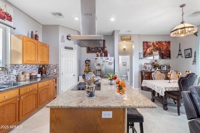 kitchen with stainless steel fridge with ice dispenser, a kitchen island, pendant lighting, and sink