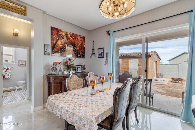 dining space featuring baseboards and a notable chandelier