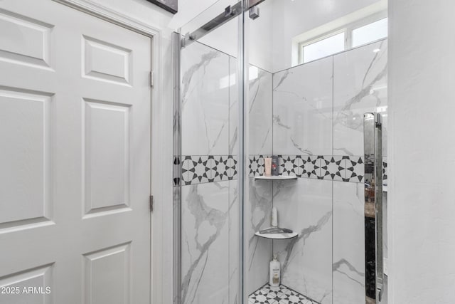 bathroom featuring a marble finish shower