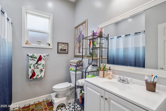 bathroom featuring baseboards, vanity, and toilet