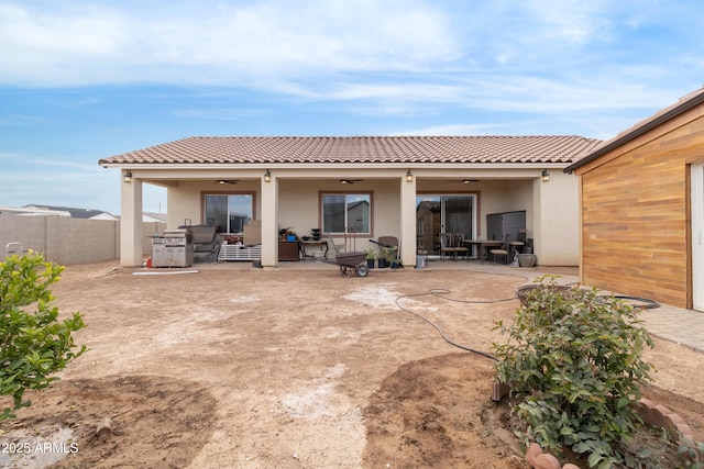 rear view of house featuring a patio area, ceiling fan, a fenced backyard, and stucco siding