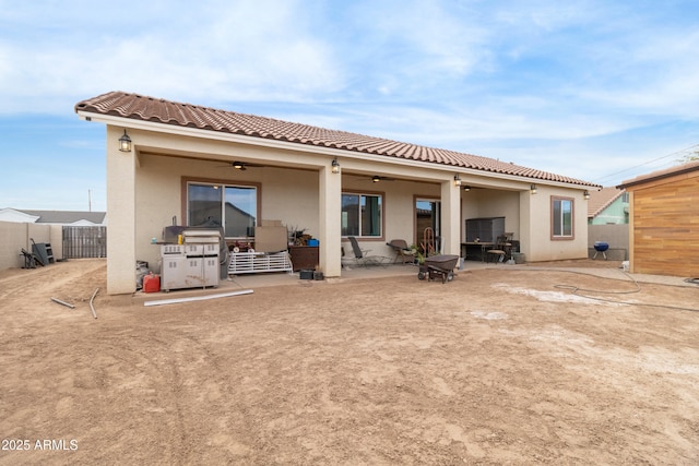 rear view of house featuring ceiling fan and a patio