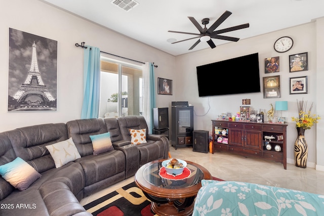 living room featuring light tile patterned floors, baseboards, visible vents, and a ceiling fan