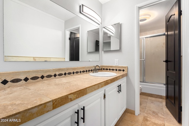 full bathroom featuring toilet, combined bath / shower with glass door, and vanity