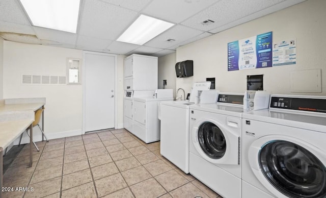 laundry room with separate washer and dryer and light tile patterned flooring