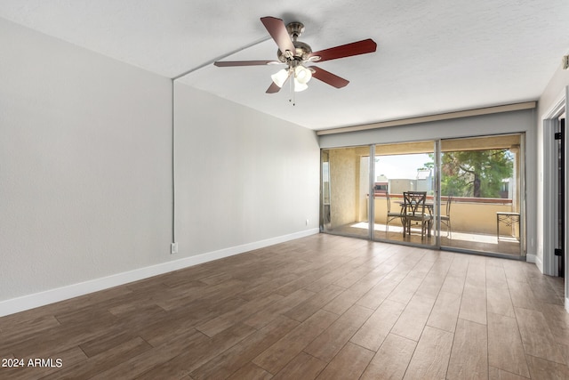 empty room featuring dark wood-type flooring and ceiling fan