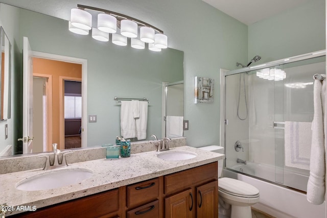 17562 W Agave Ct, Goodyear, AZ 85338 - bathroom featuring toilet, double vanity, and bath / shower combo with glass door