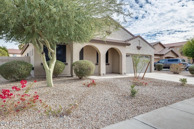 17562 W Agave Ct, Goodyear, AZ 85338 - view of front facade featuring stucco siding, concrete driveway, a garage, and covered porch